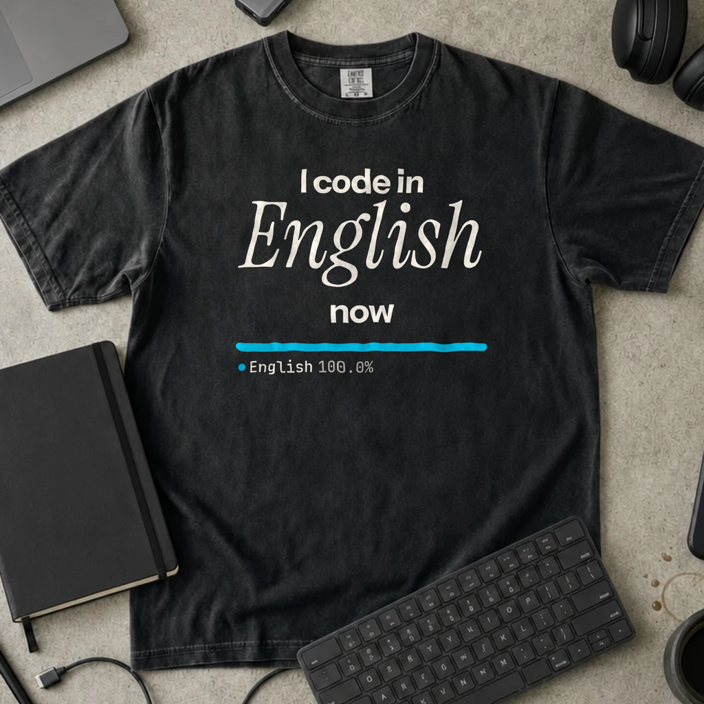 I Code in English Now Shirt — Black Comfort Colors 1717 flat lay